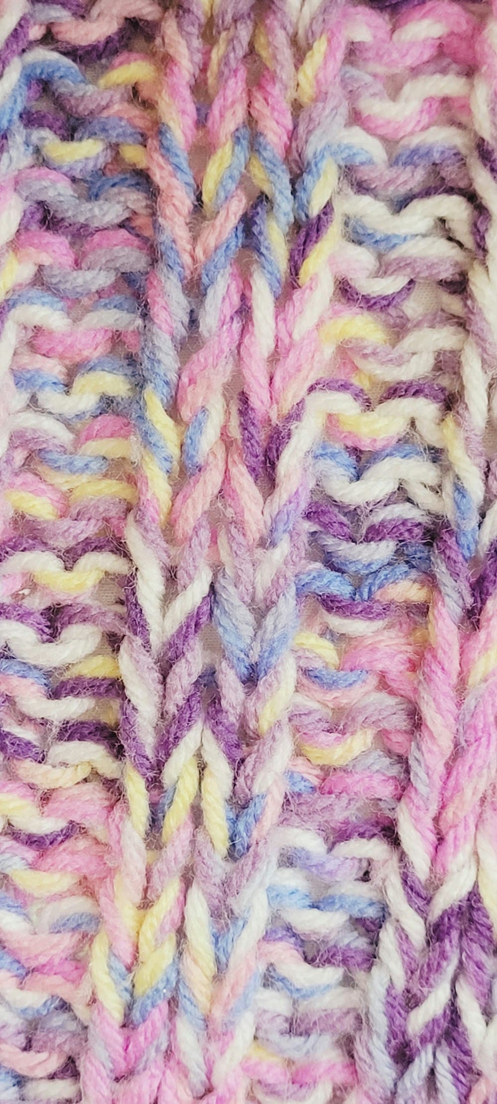 Close-up of soft pastel pink, blue, and yellow knit texture